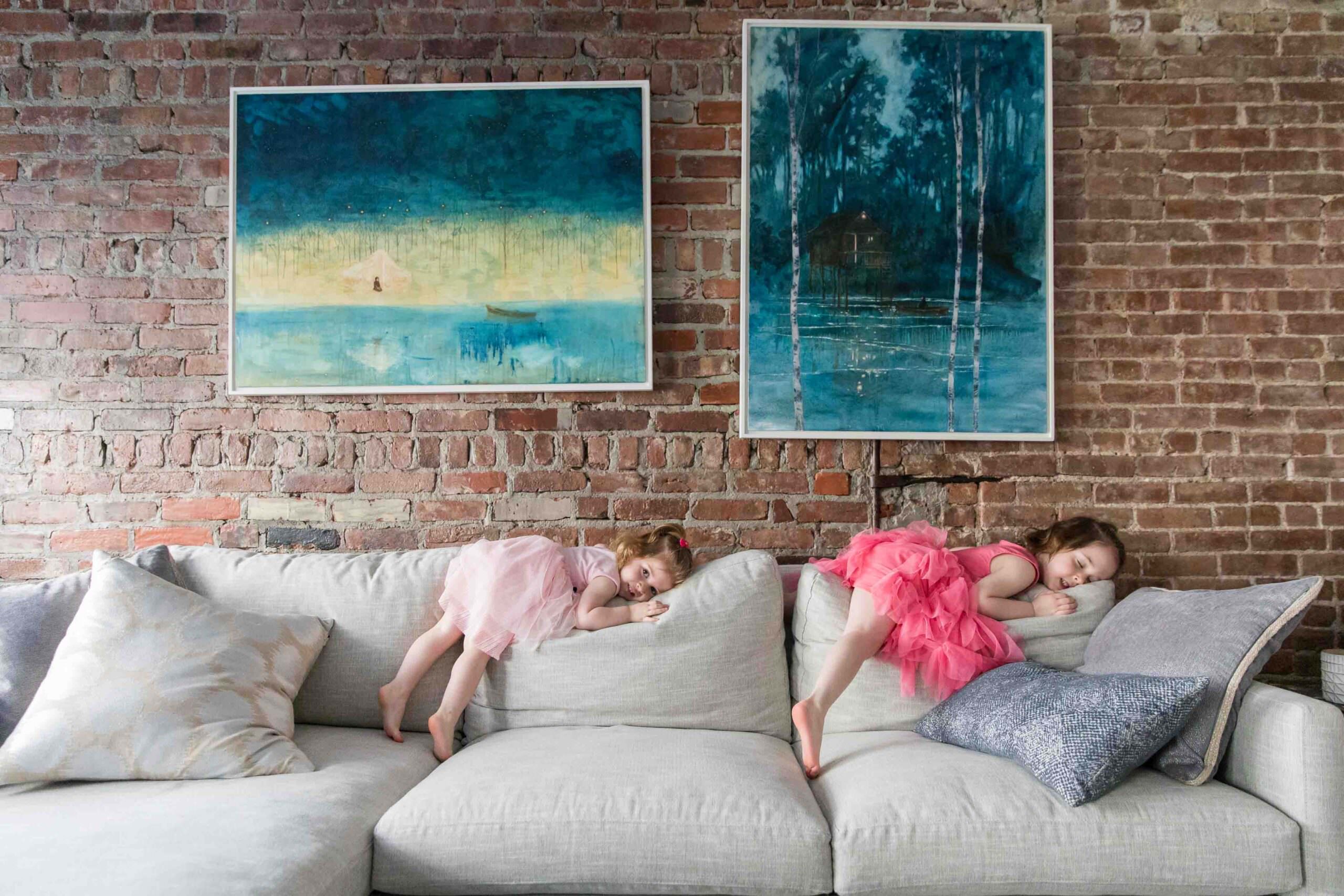 sisters in tutus sleeping on back of couch