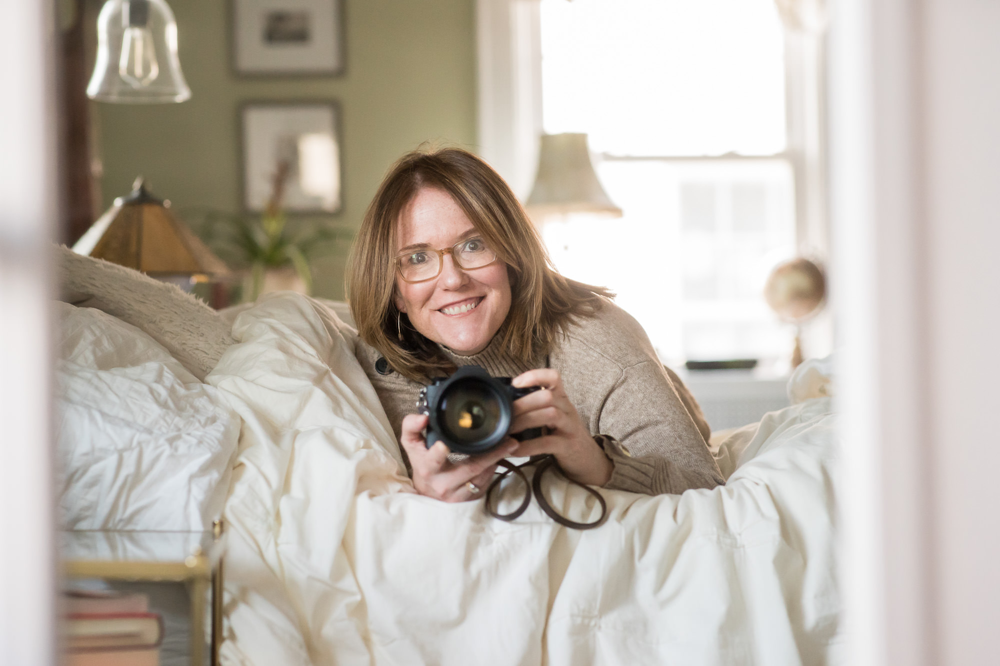 Jaye McLaughlin self portrait on bed with camera celebrating international women’s day