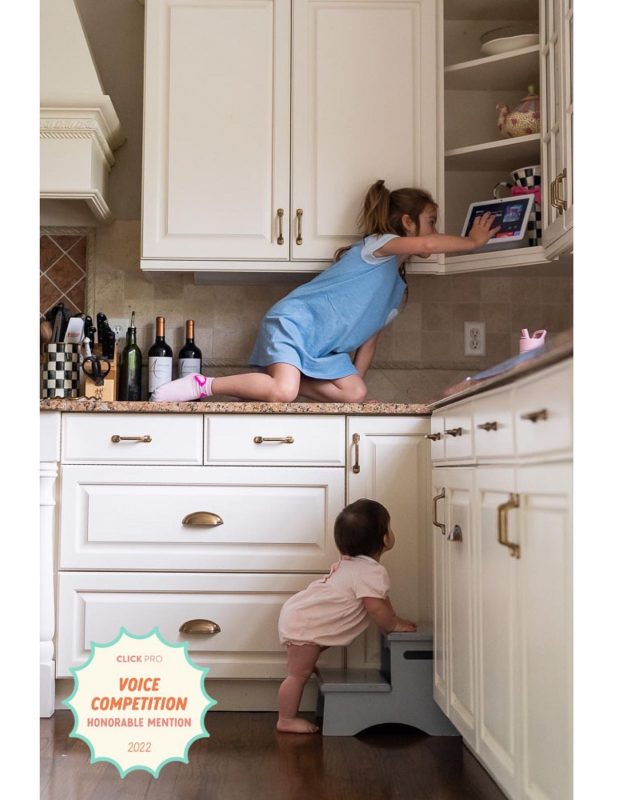toddler trying to climb on kitchen counter like older sister