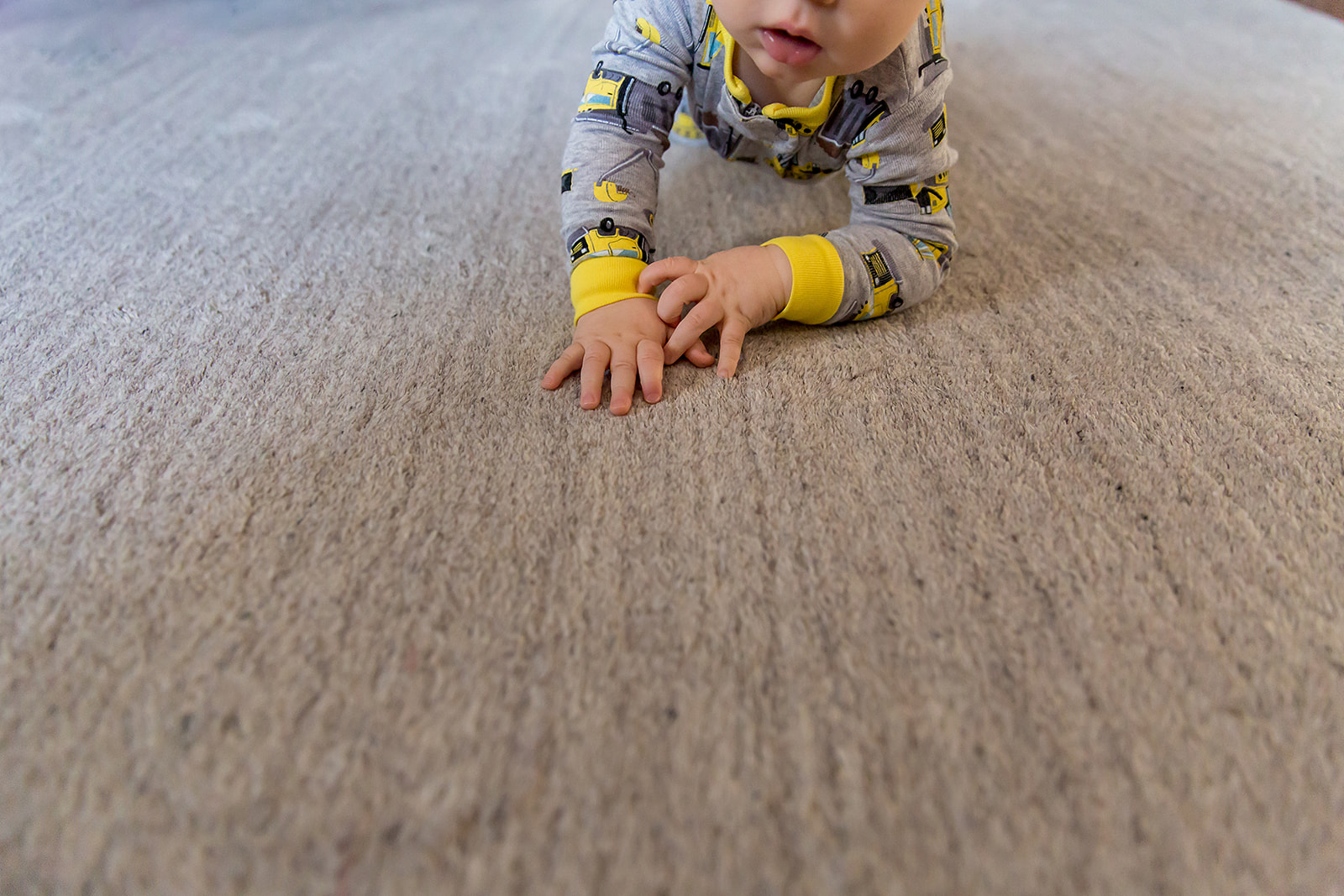 baby on carpeted floor with chubby hands with knuckle dimples