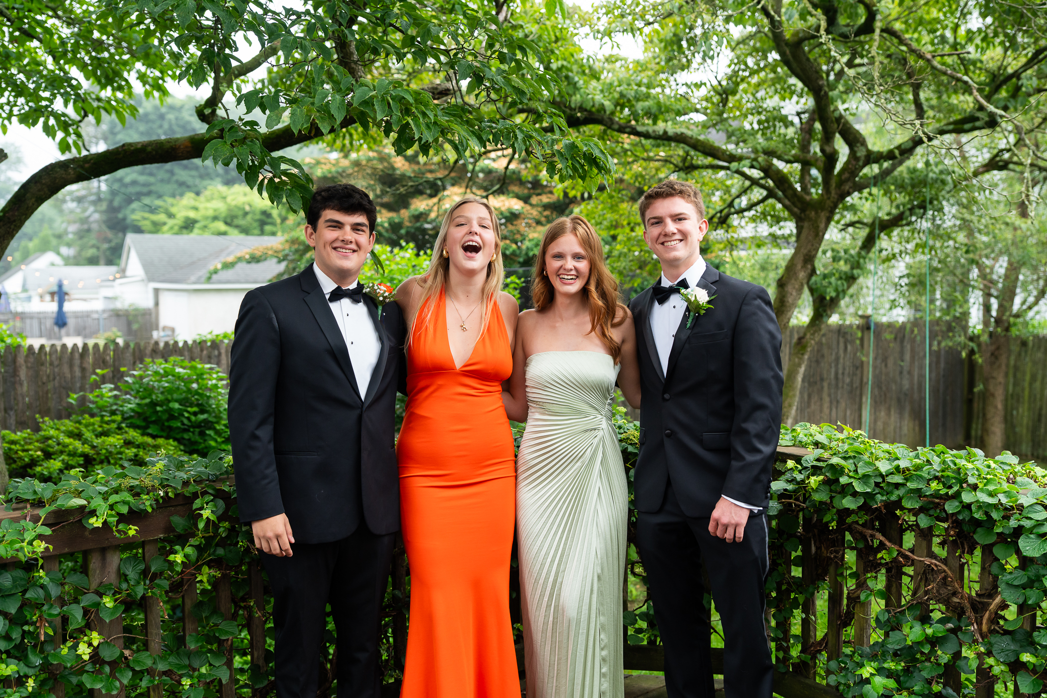 four kids posing for prom photos